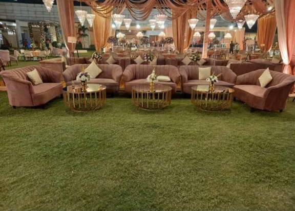 Mauve sofa seating arrangement on lawn with gold coffee tables