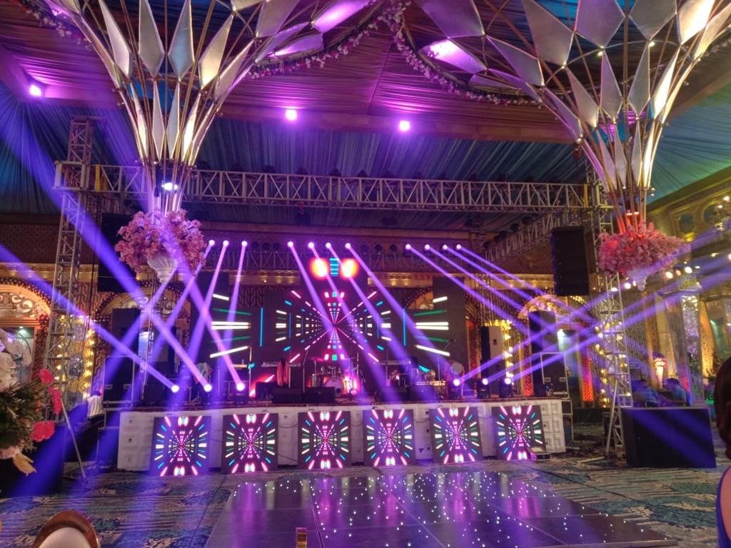 Colorful stage lighting with floral chandelier installations