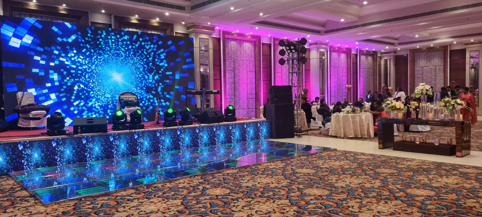 Ballroom stage with blue LED backdrop and reflective dance floor
