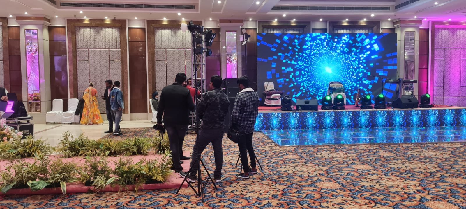 Crew setting up stage with blue tunnel LED backdrop