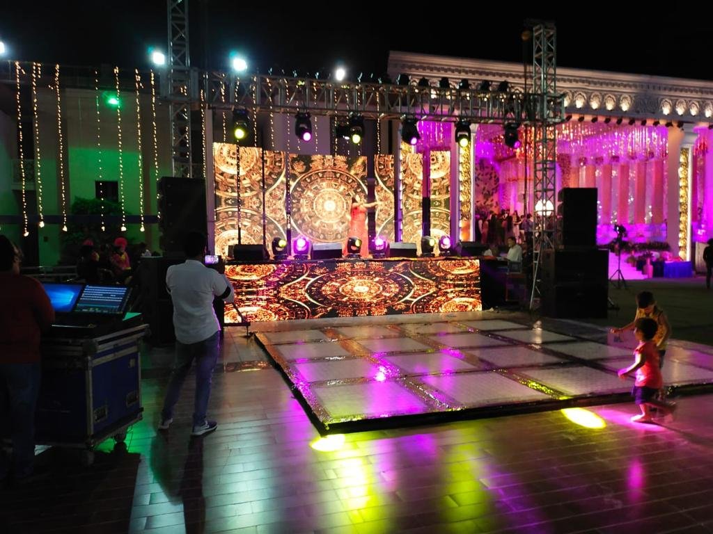 Outdoor night stage with singer and mandala LED backdrop
