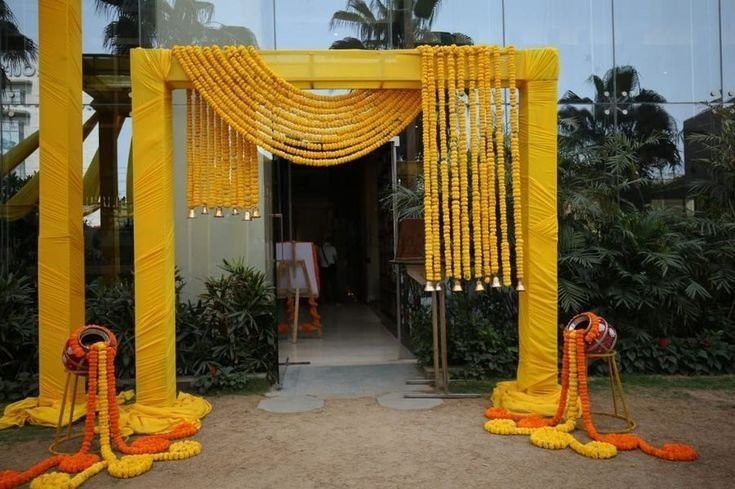 Yellow frame entrance with marigold swags and brass pot accents