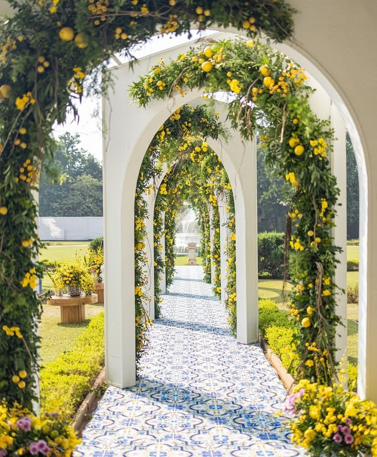 Arched floral walkway with lemon and greenery over patterned tiles