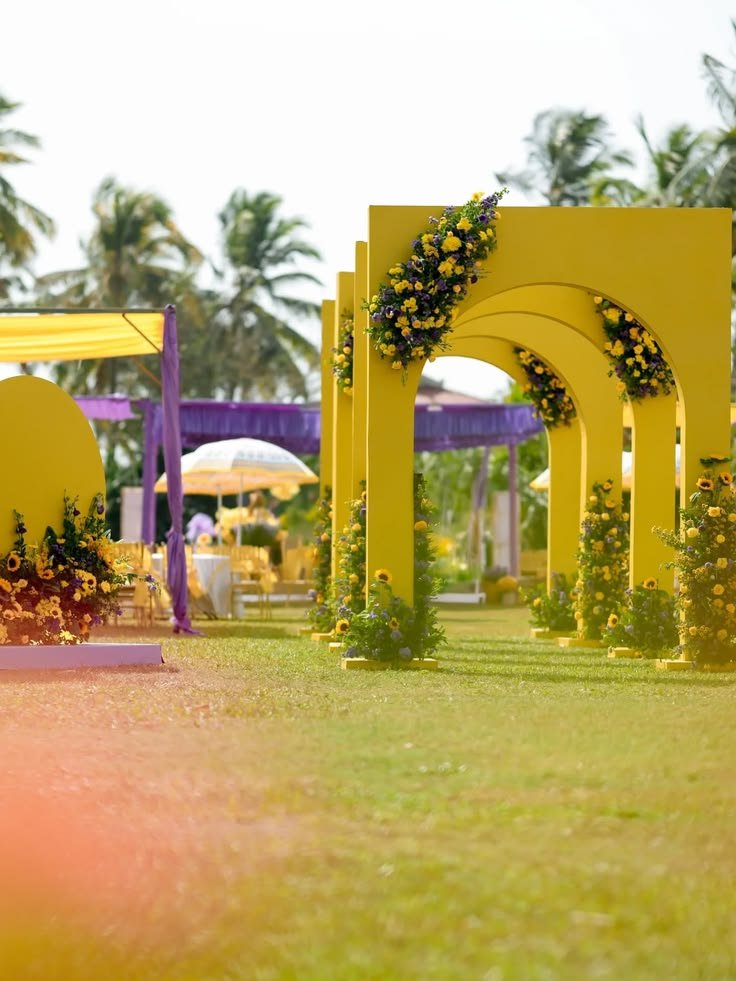 Yellow arch installation with purple drapes on lawn