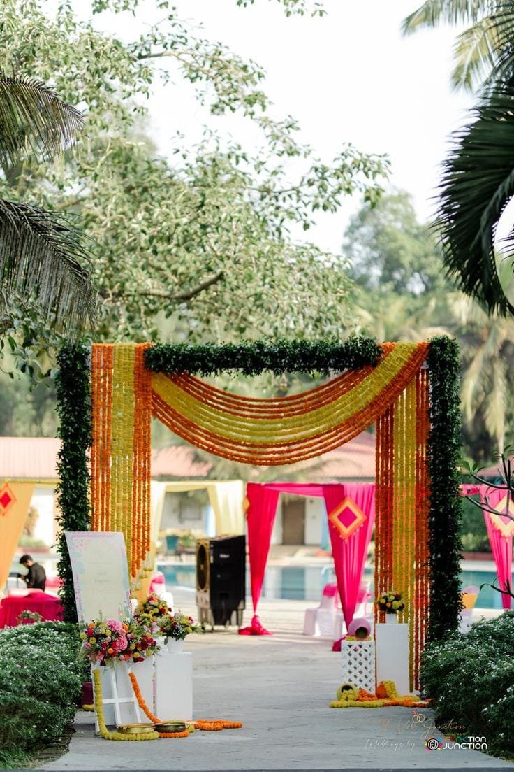 Marigold garland entrance gate with pink drapes by the pool