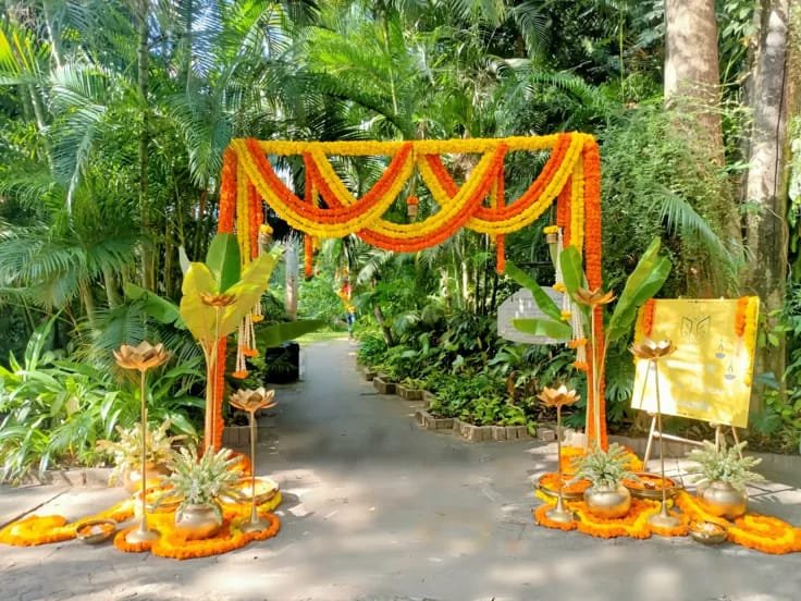 Marigold swag gateway in a garden pathway with brass urns