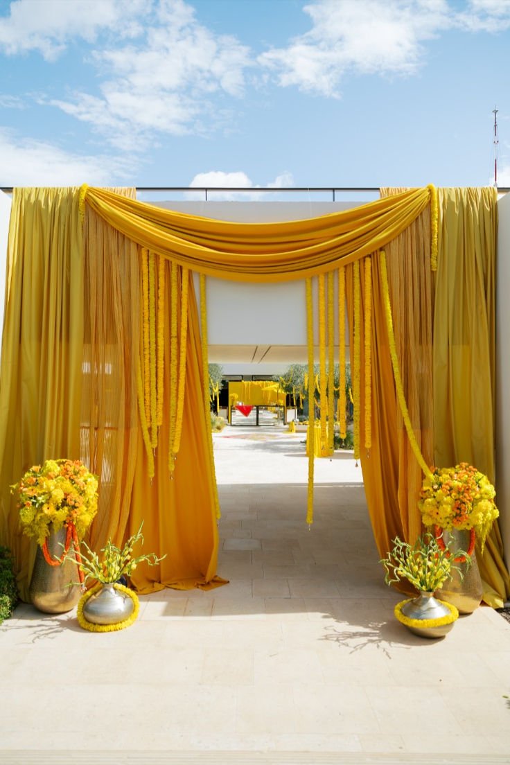 Mustard yellow draped entrance with marigold strands