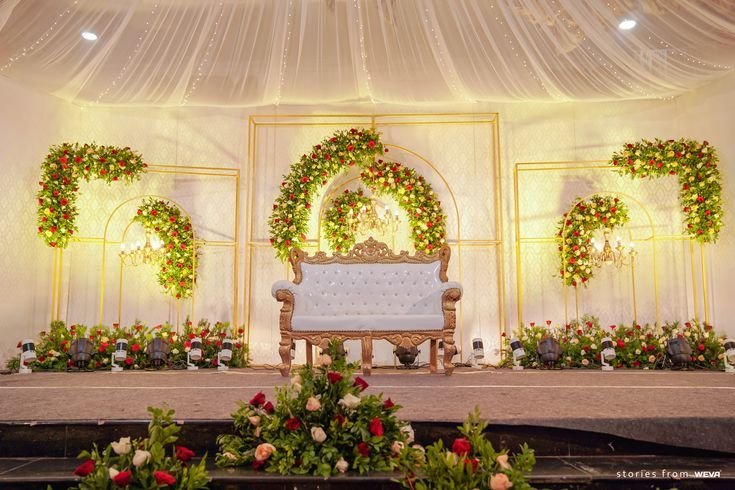 Red rose floral stage backdrop with white sofa seating