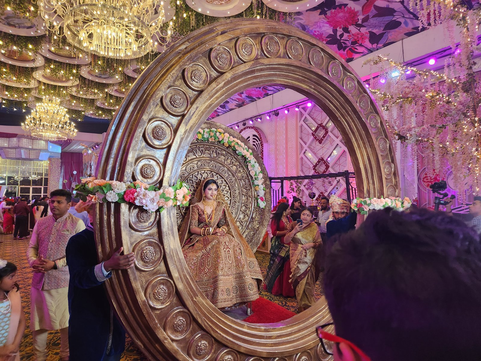 Bride seated inside a giant carved golden ring installation