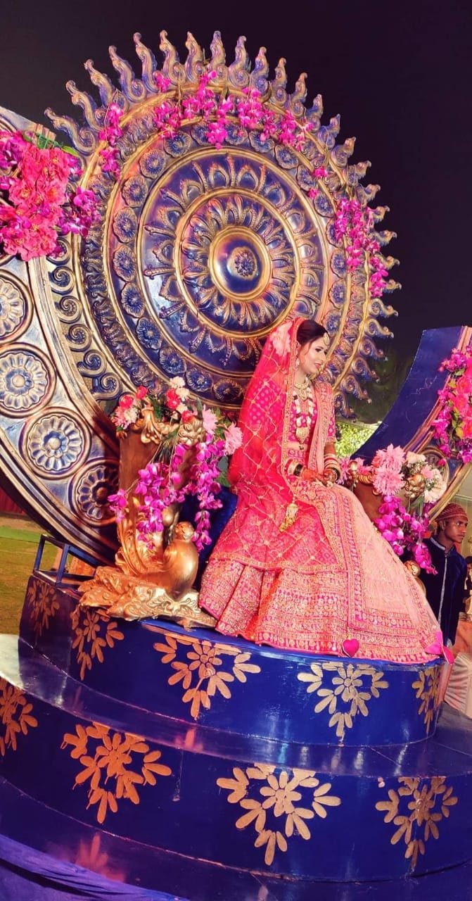 Bride on an ornate blue and gold swing installation at night